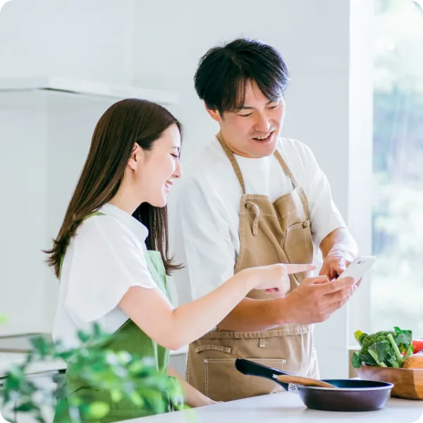 キッチンで野菜を手に話す男女